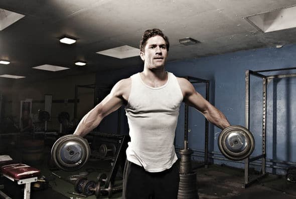 Man lifting dumbells at the gym.