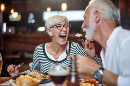 An elderly couple enjoying a meal in an upscale restaraunt