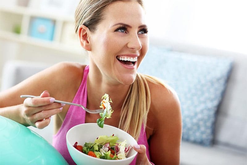 Woman getting back into healthy eating with a salad.