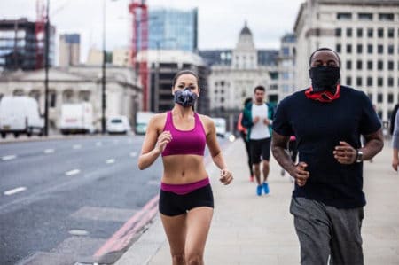 Woman and man jogging with masks on during COVID-19